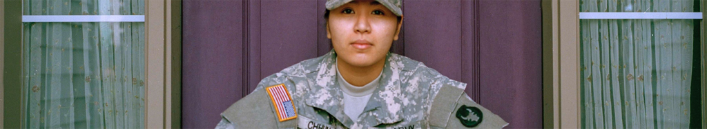 Female solider in uniform looking towards camera